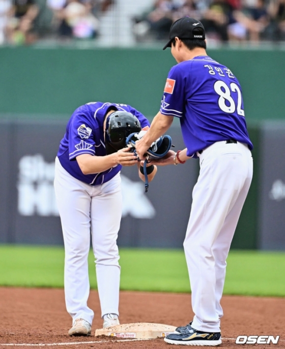 나눔 올스타 박건우(왼쪽)가 15일 부산 사직야구장에서 열린 2023 KBO 올스타전에서 1회말 안타를 치고 나간 뒤 강인권(NC) 1루 코치에게 90도 고개를 숙이며 장비를 전달하고 있다.