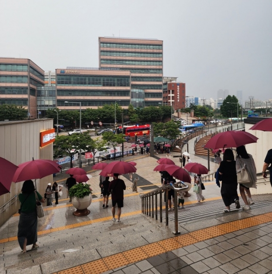 고척 구장을 찾은 야구팬들이 30일 키움-삼성전이 끝난 후 쏟아진 갑작스러운 비에 키움 구단이 제공한 우산을 쓰고 귀가 중이다.