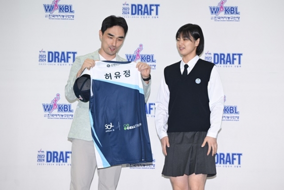 인천 신한은행 구나단(왼쪽) 감독이 지명한 허유정에게 유니폼을 건네고 있다. /사진=WKBL 제공