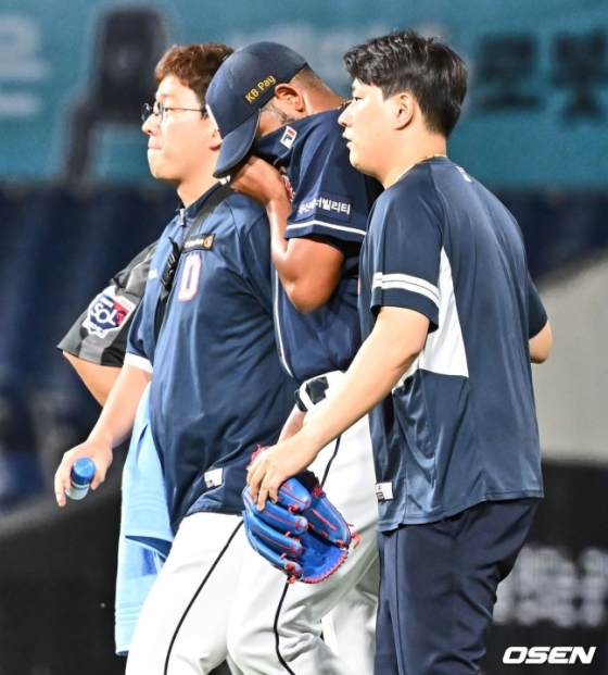 두산 알칸타라(가운데)가 23일 창원 NC전에서 6회 말 박민우의 타구에 오른손을 맞은 뒤 강판되고 있다.