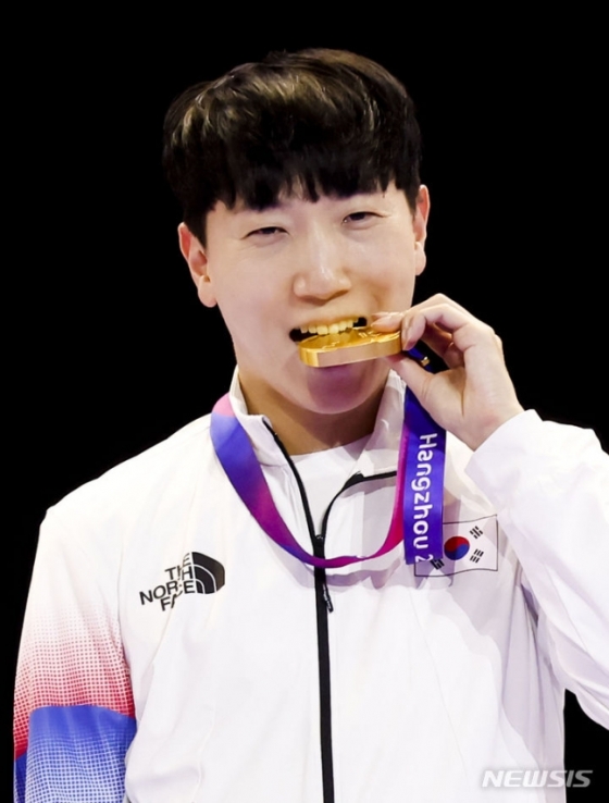 김관우가 28일(한국시간) 중국 항저우 E스포츠센터에서 열린 2022 항저우 아시안게임 E스포츠 &#039;스트리트 파이터 V&#039; 시상식에서 금메달을 깨물고 있다. /사진=뉴시스
