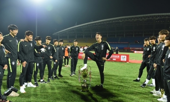 한국 U-18 대표팀이 2019 판다컵 우승 트로피에 발을 올리고 있는 모습. /사진=중국 시나스포츠 캡처