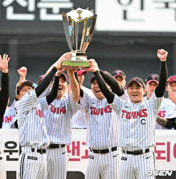 염경엽(왼쪽) LG 감독과 임찬규, 김현수, 오지환이 우승 트로피를 들어 올리며 기뻐하고 있다. 