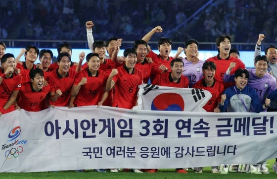  2022 항저우 아시안게임 우승 축하 현수막과 함께 기념촬영하는 한국 축구대표 선수들. /사진=뉴시스