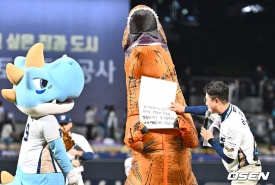 NC 팬 '공룡좌'가 19일 창원NC파크에서 열린 2023 KBO 와일드카드 결정전 1차전에서 시구 행사에 앞서 메시지를 들고 있다. 