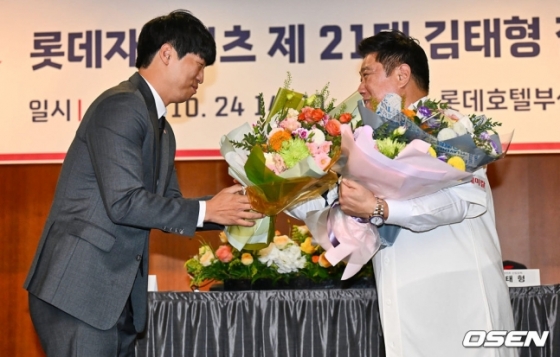 롯데 구승민(왼쪽)이 24일 열린 롯데 신임 감독 취임식에서 김태형 감독에게 꽃다발을 전달하고 있다.