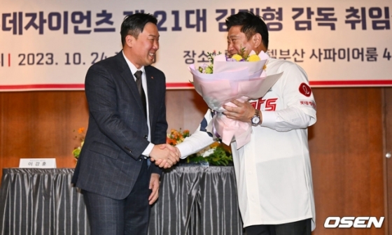 롯데 안치홍(왼쪽)이 24일 열린 신임 감독 취임식에서 김태형 감독에게 꽃다발을 전해주고 있다.