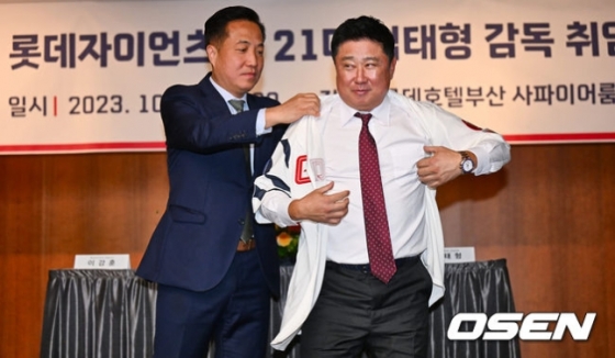 이강훈 롯데 구단 대표이사(왼쪽)가 24일 열린 롯데 제21대 감독 취임식에서 김태형 신임 감독에게 유니폼을 입히고 있다.