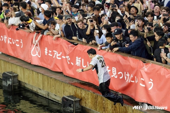 한신의 우승을 축하하기 위해 오사카 시내 도톤보리강에 뛰어드는 한 야구팬.  /AFPBBNews=뉴스1