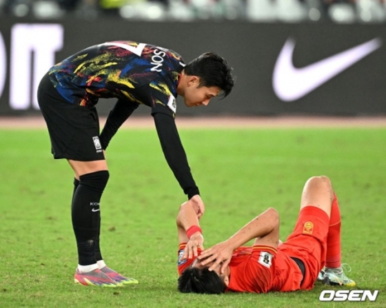 쓰러져 있는 중국 선수를 향해 손을 내미는 손흥민(왼쪽). /사진=OSEN