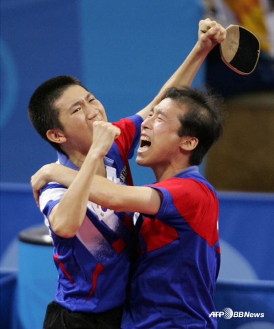 유승민(왼쪽)이 2004 아테네 올림픽 남자 탁구 단식 결승에서 승리한 후 김택수 코치와 함께 기뻐하고 있다. /AFPBBNews=뉴스1