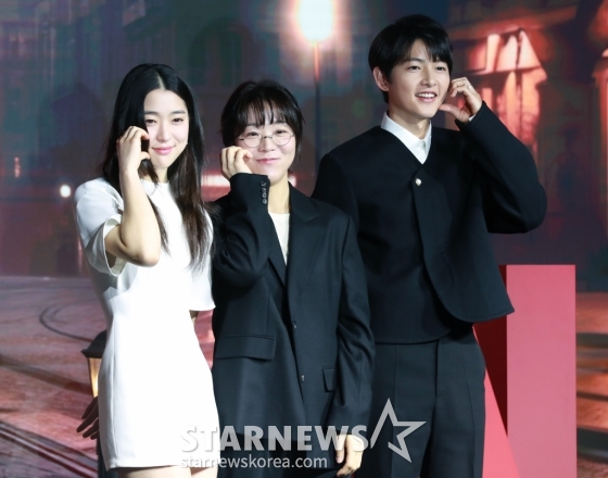 배우 최성은, 김희진 감독, 배우 송중기가 27일 오전 서울 마포구 호텔 나루 서울 엠겔러리에서 진행된 넷플릭스 영화 &#039;로기완&#039; 제작보고회에 참석해 포즈를 취하고 있다.  삶의 마지막 희망을 안고 벨기에에 도착한 탈북자 기완과 삶의 이유를 잃어버린 여자 마리가 서로에게 이끌리듯 빠져드는 이야기를 그린 영화 &#039;로기완&#039;은 3월 1일 공개된다. /2024.02.27 /사진=이동훈