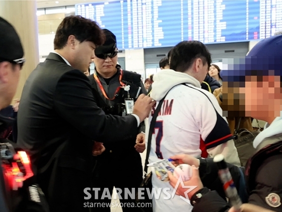 한화 이글스 투수 류현진(왼쪽)이 4일 인천국제공항을 통해 귀국해 현장을 찾은 팬에게 사인을 해주고 있다. /사진=김진경 대기자