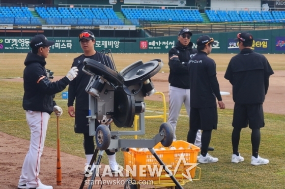 노시환(왼쪽에서 2번째)이 김재걸 코치에게 수비 송구와 관련된 조언을 얻고 있다. /사진=안호근 기자