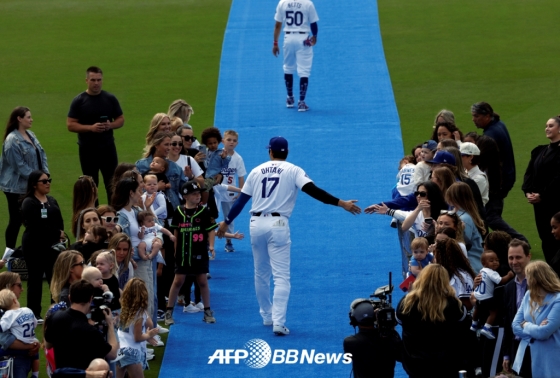 오타니 쇼헤이가 29일 미국 캘리포니아주 다저스타디움에서 열린 세인트루이스 카디널스와 홈 경기를 앞두고 경기장에 입장하면서 동료들 가족과 하이파이브를 하고 있다. /AFPBBNews=뉴스1