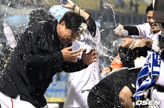 류현진이 30일 대전 SSG전에서 KBO 리그 통산 100승을 달성하고 동료들로부터 축하의 물 세례를 받고 기뻐하고 있다. 