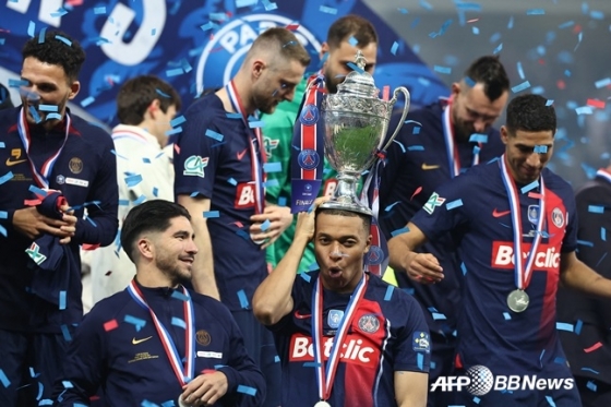킬리안 음바페(가운데)가 26일(한국시간) 프랑스 릴의 스타드 피에르-모루아에서 열린 PSG 대 올랭피크 리옹의 '2023~24시즌 쿠프 드 프랑스' 결승전에서 승리한 뒤 우승컵을 머리에 놓고 기뻐하고 있다. /AFPBBNews=뉴스1