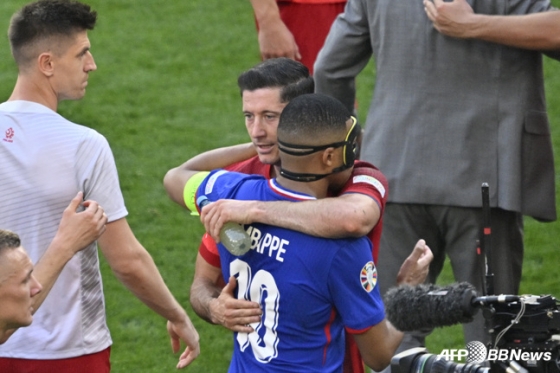킬리안 음바페(파란색 유니폼)와 로베르트 레반도프스키가 경기 후 포옹을 나누고 있다. /AFPBBNews=뉴스1