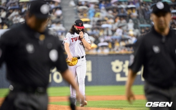 LG 트윈스 케이시 켈리가 20일 잠실 두산전에서 3회 우천으로 중단되자 투구 도중 마운드를 내려오고 있다.