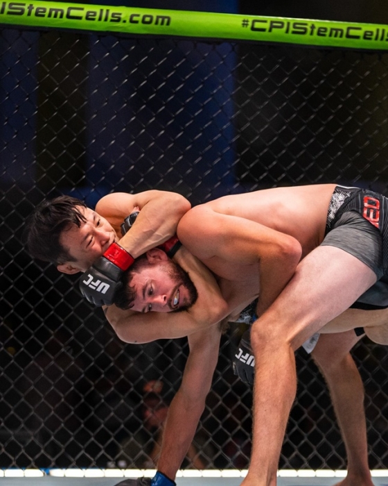 최두호(왼쪽)가 알지오의 머리를 감싸며 공격을 하고 있다. /사진=UFC 코리아 SNS 갈무리