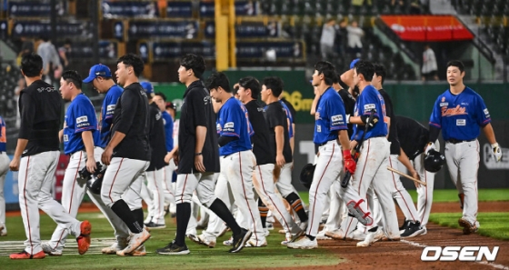 한화 선수들이 우천중단까지 겹치며 무박 2일에 걸친 혈투 끝에 패한 뒤 고개를 숙이고 더그아웃으로 향하고 있다.