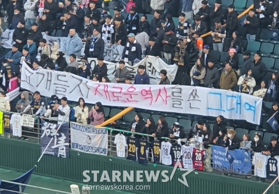 서울이랜드 팬들이 지난 8일 전주월드컵경기장에서 열린 전북 현대 대 서울이랜드의 &#039;하나은행 K리그 승강 플레이오프(PO) 2024&#039; 2차전 원정에서 1-2로 패한 뒤 &#039;고개들자, 새로운 역사를 쓴 그대여&#039;라는 걸개를 들어올리고 있다./사진=박재호 기자