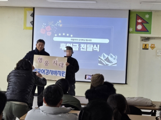 히말라야 오지학교 탐사대 출발 전 발대식에서 한국어 교사 연봉을 전달하고 있다.