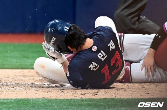 롯데 전민재가 투구에 머리를 맞은 후 고통스러워하고 있다. 