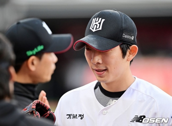 오원석이 동료들의 환호를 받으며 미소와 함께 더그아웃으로 향하고 있다.