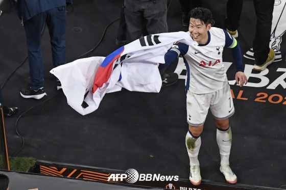 토트넘 주장 손흥민이 22일 2024~2025 UEFA 유로파리그 우승 이후 태극기를 흔들며 기뻐하고 있다. /AFPBBNews=뉴스1