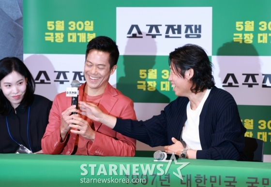 배우 유해진이 29일 오후 서울 CGV용산아이파크몰에서 진행된 영화 &#039;소주전쟁&#039; 언론배급시사회 및 기자간담회에서 바이런 만의 마이크를 바로잡아주고 있다.  1997년 IMF 외환위기, 소주 회사가 곧 인생인 재무이사 종록과 오로지 성과만 추구하는 글로벌 투자사 직원 인범이 대한민국 국민 소주의 운명을 걸고 맞서는 이야기 &#039;소주전쟁&#039;은 오는 30일 개봉한다. /2025.05.29 /사진=이동훈 photoguy@