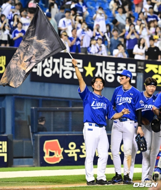 삼성 김태훈이 1일 잠실 LG전 승리 후 사자깃발을 들고 미소짓고 있다. 