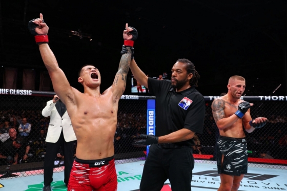 고석현(왼쪽)이 오반 엘리엇과 경기서 승리한 뒤 두 팔을 들며 포효하고 있다. /사진=UFC 제공