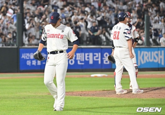 롯데 김진욱(왼쪽)이 8일 사직 두산전에서 8회초 제이크 케이브에게 동점 투런 홈런을 맞고 마운드를 내려가고 있다. 