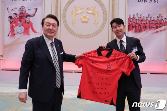 윤석열(왼쪽) 대통령이 8일 오후 청와대 영빈관에서 열린 카타르 월드컵 축구 국가대표팀 환영 만찬에서 친필 사인한 축구 대표팀 유니폼을 주장 손흥민에게 전달하고 있다. /사진=대통령실 제공(뉴스1)