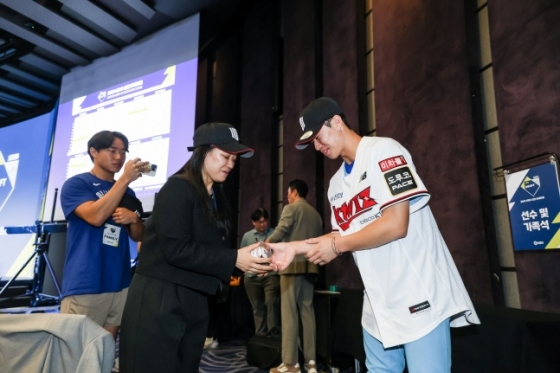 ㅁKT 위즈의 1라운드 지명을 받은 부산고 원상현(오른쪽)이 14일 서울특별시 중구 소공동에 위치한 웨스틴조선호텔 그랜드볼룸에서 진행된 2024 KBO 신인드래프트가 끝난 후 부모님께 전달할 첫 사인공을 전하고 기념 사진을 촬영했다. /사진=KT 위즈