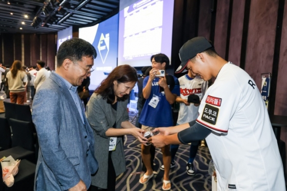 ㅁKT 위즈의 1라운드 지명을 받은 강릉고 육청명(오른쪽)이 14일 서울특별시 중구 소공동에 위치한 웨스틴조선호텔 그랜드볼룸에서 진행된 2024 KBO 신인드래프트가 끝난 후 부모님께 전달할 첫 사인공을 전하고 기념 사진을 촬영했다. /사진=KT 위즈