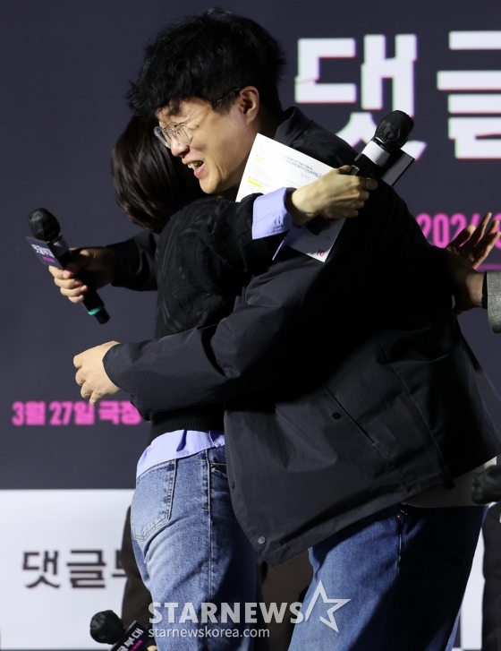 (서울=뉴스1) 김진환 기자 = 안국진 감독이 4일 서울 광진구 아차산로 롯데시네마 건대입구에서 열린 영화 ‘댓글부대’ 제작보고회에 참석해 군대 시절 라디오에 사연을 보냈던 일화를 밝힌 뒤 박경림과 포옹을 하고 있다.   ‘댓글부대’는 대기업에 관한 기사를 쓴 후 정직당한 기자 임상진에게 온라인 여론을 조작했다는 익명의 제보자가 나타나면서 벌어지는 이야기를 다룬 영화로 오는 27일 개봉한다. 2024.3.4/뉴스1  Copyright (C) 뉴스1. All rights reserved. 무단 전재 및 재배포,  AI학습 이용 /사진=(서울=뉴스1) 김진환 기자
