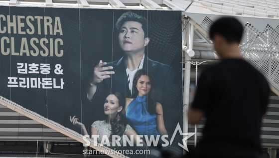(서울=뉴스1) 박지혜 기자 = 22일 오후 서울 송파구 올림픽공원 KSPO돔(체조경기장)에 설치된 '월드 유니온 오케스트라 슈퍼 클래식 : 김호중 & 프리마돈나’ 현수막 앞으로 시민들이 지나가고 있다. ‘음주 뺑소니’ 혐의로 조사를 받고 있는 트로트 수 김호중(33)이 경찰의 구속영장 신청에도 오는 23~24일 예정된 클래식 공연에 나선다. 김호중의 소속사 생각 엔터테인먼트 측 관계자는 이날 뉴스1에 "경찰이 구속영장을 신청한 사실을 방금 확인했다"라며 "그럼에도 오는 23~24일로 예정된 공연은 진행할 계획"이라고 /사진=(서울=뉴스1) 박지혜 기자