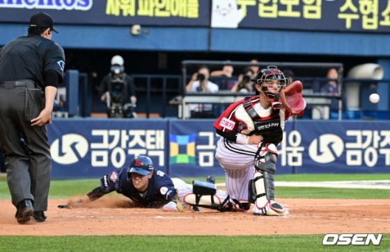 롯데 황성빈(가운데)이 16일 잠실 LG전에서 7회초 무사 1,2루 때 LG 오스틴의 송구 실책을 틈타 홈에서 슬라이딩을 시도하고 있다.