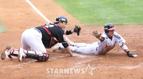 '2024 KBO 포스트시즌 준플레이오프 2차전' LG-KT전이 6일 서울 잠실야구장에서 열렸다. LG 5회말 무사 2루 2루주자 신민재(오른쪽)가 오스틴의 우중간 안타 때 홈으로 뛰어들었으나 KT 포수 장성우에 태그아웃되고 있다.