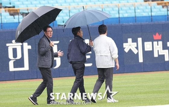 '2024 KBO 포스트시즌 플레이오프 2차전' 삼성LG전'이 14일 대구 삼성라이온즈파크에서 열렸다. 박근찬 사무총장(가운데)과 김시진 감독관이 대형 방수포가 깔려 있는 야구장을 살피고 있다. /사진=김진경 대기자