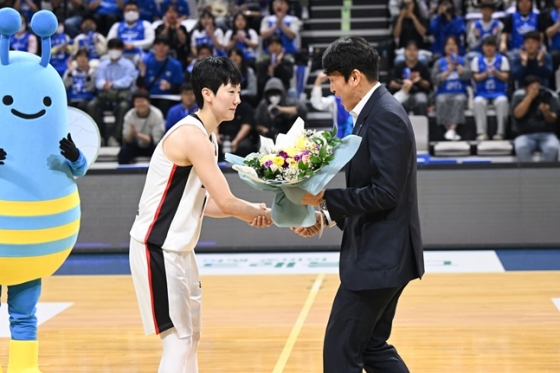 우리은행 위성우 감독(오른쪽)이 BNK 박혜진에게 꽃다발을 선물하고 있다. /사진=WKBL 제공