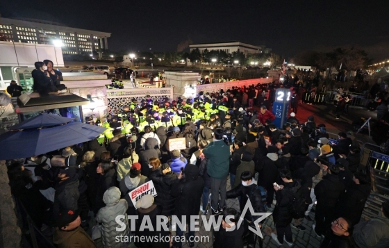 (서울=뉴스1) 장수영 기자 = 윤석열 대통령의 비상계엄 해제 요구 결의안이 국회 본회의에서 통과된 4일 새벽 서울 여의도 국회 정문 앞에 모인 시민들이 윤 대통령을 규탄하고 있다. 여야는 이날 본회의에서 재석 190명 중 찬성 190명으로 비상계엄 해제 요구 결의안을 가결 처리했다. 이에 따라 계엄령 선포는 무효가 됐다고 국회의장실은 설명했다. 2024.12.4/뉴스1 Copyright (C) 뉴스1. All rights reserved. 무단 전재 및 재배포, AI학습 이용 금지. /사진=(서울=뉴스1) 장수영 기자
