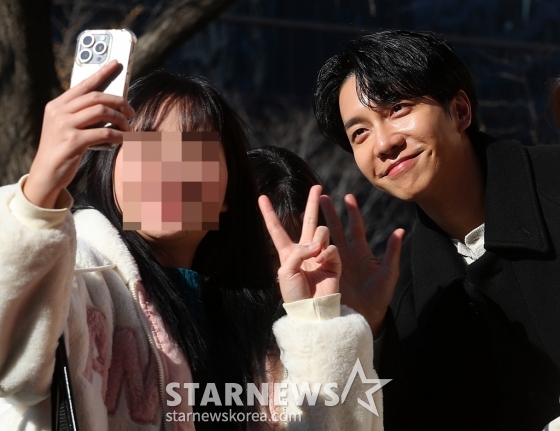 배우 이승기가 10일 오후 서울 중구 한국프레스센터 앞 광장에서 진행된 영화 '대가족' 만두트럭 이벤트 행사에서 팬과 사진 촬영을 하고 있다.  '대가족'은 스님이 된 아들(이승기 분) 때문에 대가 끊긴 만두 맛집 '평만옥' 사장(김윤석)에게 세상 본 적 없던 귀여운 손주들이 찾아오면서 생각지도 못한 기막힌 동거 생활을 하게 되는 가족 코미디. 11일 개봉한다. 2024.12.10 /사진=김창현 chmt@