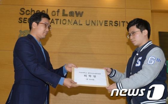 박준성 서울대 로스쿨 학생회장이 이우선 서울대 로스쿨 행정주임에게 자퇴서를 제출하고 있다. /사진=뉴스1
