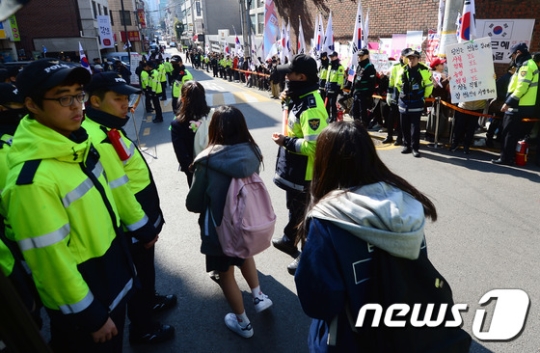서울 강남구 삼성동 박 전 대통령 사저 앞에서 학생들이 박근혜 전 대통령 지지자들의 집회를 바라보며 하교 하는 모습./사진=뉴스1