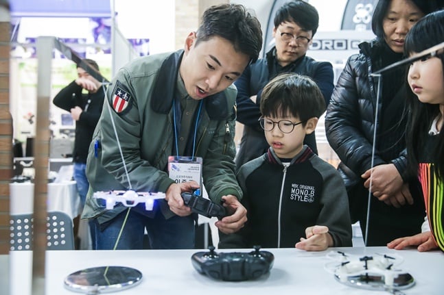 지난해 4월 전주월드컵경기장에서 열린 ‘2018년 3D프린팅*드론 코리아 엑스포’에서 드론 전시부스를 찾은 참관객들이 드론 기술에 대한 설명을 듣고 있다. /사진= 지디넷코리아 제공