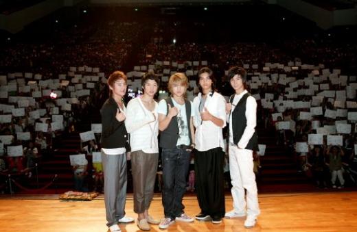 동방신기가 도장사인회 현장에서 팬들과 함께 기념촬영을 했다. 팬들이 들고 있는 하얀 종이는 도장사인을 받은 사인지