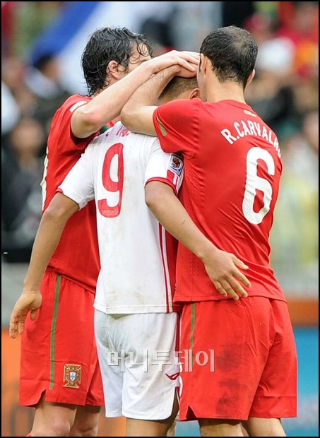 ↑정대세가 경기가 끝난 후 포르투갈 선수들에게 위로 받고 있다. 포르투갈의 중앙 수비수 히카르두 카르발류(사진 맨 우측)는 경기 후 인터뷰에서 "역시 가장 인상적인 선수를 꼽으라면 북한의 9번(정대세)이다"고 밝혔다.